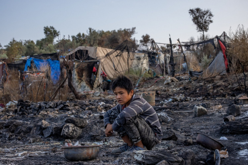Daniel Etter: Nawid Rezaie, 11, from Baghlan, Afghanistan and his family search for belongings that survived the fire of the so-called hotspot for refugees and migrants in Moria, Lesbos, Greece, Sept. 15, 2020. The family lived in this spot in the so-called jungle next to the offciila camp. Thousands of people, mostly families from Afghanistan, remained stranded on a road after a  fire burned down this camp. It was used to house asylum seekers and process their applications. Before it burned down, it  was overcrowded and many asylum seekers remained stuck there for months.