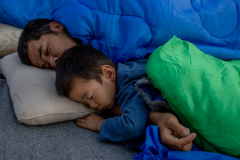 Daniel Etter: Afghan refugees Mahdi Amiri and his son Amir Abbas sleep near the burned-out camp for asylum seekers in the village of Moria, Lesbos, Greece, Sept. 17, 2020. The family was displaced to nearby olive groves. Thousands of people, mostly families from Afghanistan, were stranded on a road and in olive groves after the fire. Before it burned down, the camp in Moria was overcrowded and many asylum seekers remained stuck there for months. Daniel Etter: Afghan refugees Mahdi Amiri and his son Amir Abbas sleep near the burned-out camp for asylum seekers in the village of Moria, Lesbos, Greece, Sept. 17, 2020. The family was displaced to nearby olive groves. Thousands of people, mostly families from Afghanistan, were stranded on a road and in olive groves after the fire. Before it burned down, the camp in Moria was overcrowded and many asylum seekers remained stuck there for months.