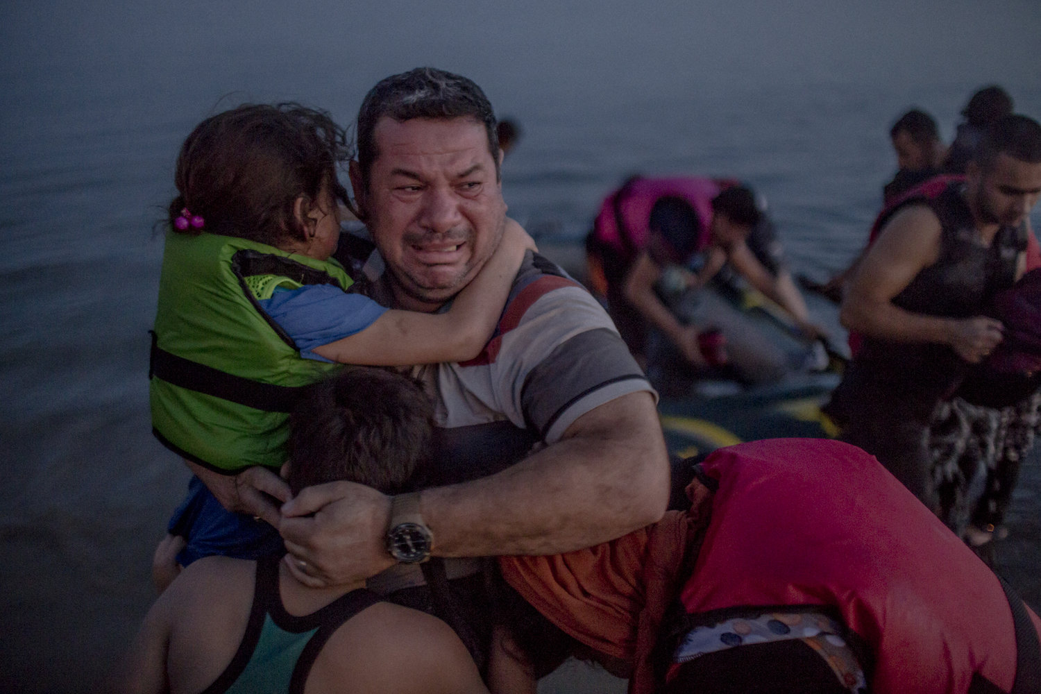 Daniel Etter: Laith Majid Al Amirij, an Iraqi refugee from Baghdad, breaks out in tears of joy, holding his son Taha and his daughter Nour, after they arrived safely on a beach of the Greek island of Kos, Greece, Aug. 15, 2015. The group crossed over from the Turkish resort town of Bodrum and on the way their flimsy rubber boat, crammed with about 12 men, women and children, lost air. Fearing that they get sent back to Turkey and upon being told so by their smuggler, Mr. Al Amirij’s wife initially identified them as Syrians from Deir Ezzor. The family has since made it to Berlin, Germany.